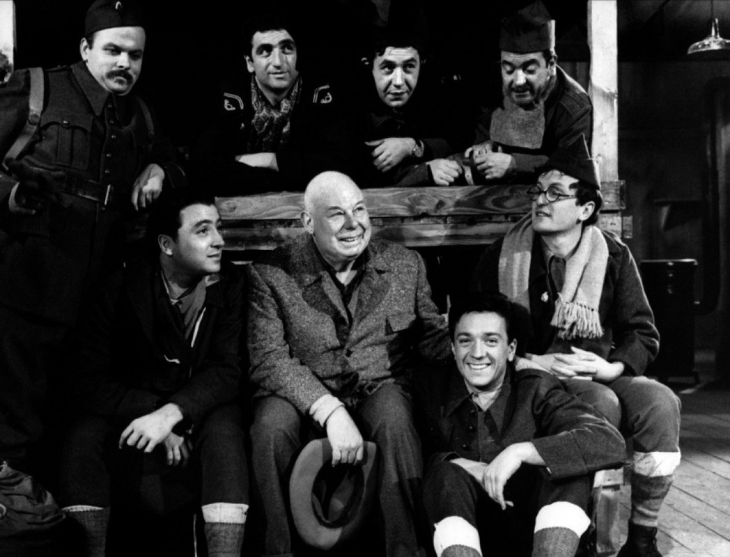 Jean Carmet در صحنه فیلم سینمایی The Elusive Corporal به همراه Claude Rich، Jean-Pierre Cassel، Claude Brasseur، Jean Renoir، Jacques Jouanneau و Mario David