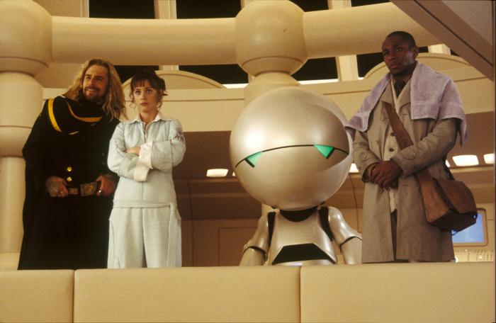 Yasiin Bey در صحنه فیلم سینمایی راهنمای سفر مجانی به کهکشان به همراه زویی دشانل، سم راک‌ول و وارویک دیویس
