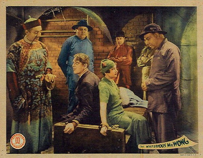 Wallace Ford در صحنه فیلم سینمایی The Mysterious Mr. Wong به همراه E. Alyn Warren، Edward Peil Sr.، Arline Judge و Bela Lugosi