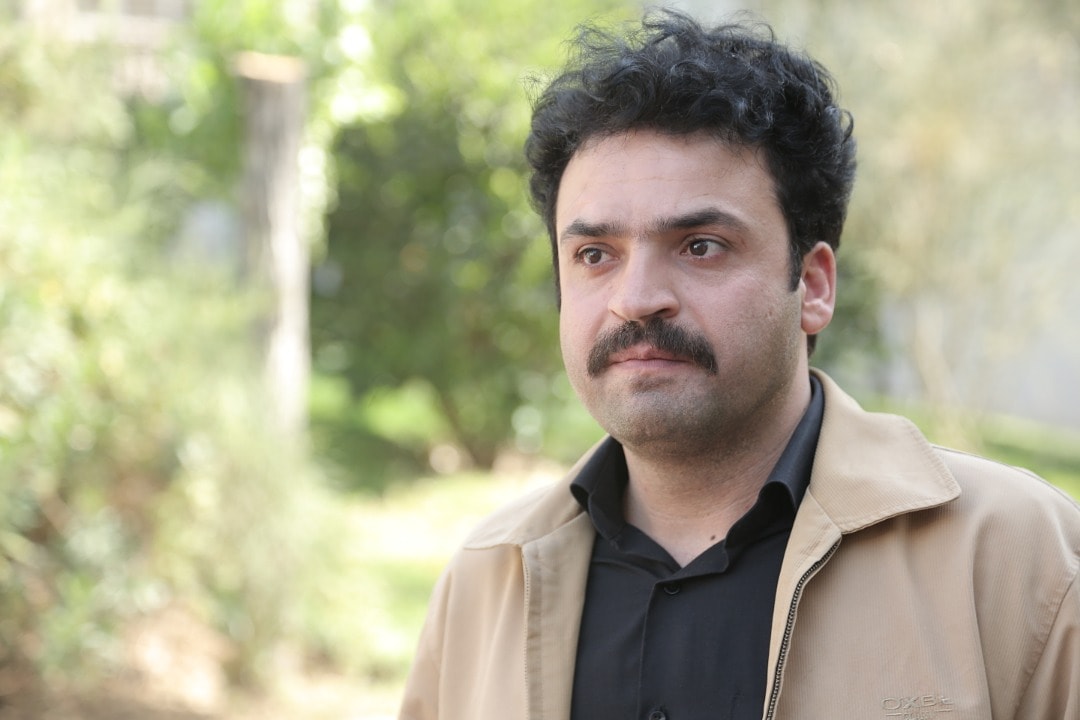تصویری از علی میرزایی، بازیگر و نوازنده سینما و تلویزیون در حال بازیگری سر صحنه یکی از آثارش
