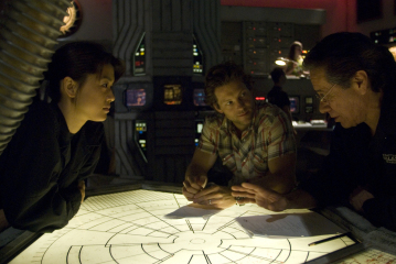 Jamie Bamber در صحنه سریال تلویزیونی ناوبر فضایی گالاکتیک به همراه Grace Park و ادوارد جیمز آلموس