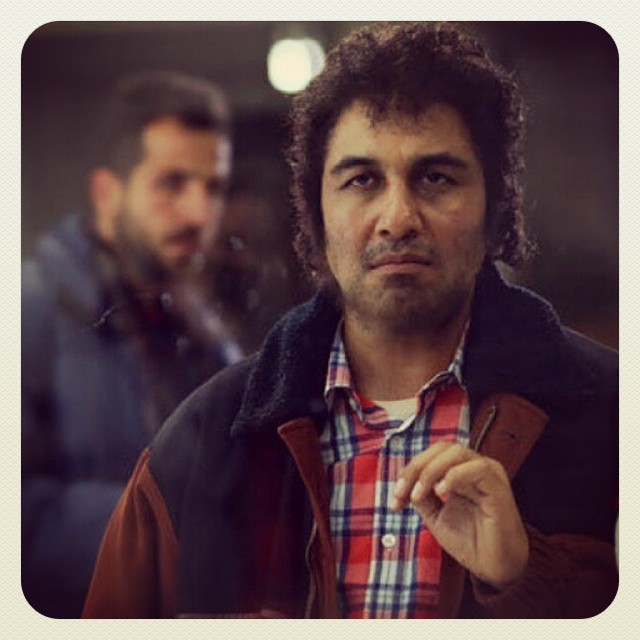 تصویری از رضا عطاران، بازیگر و نویسنده سینما و تلویزیون در حال بازیگری سر صحنه یکی از آثارش