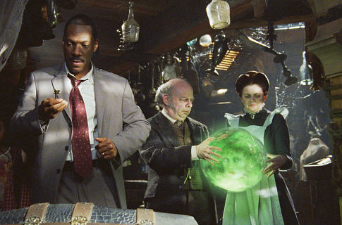 Wallace Shawn در صحنه فیلم سینمایی The Haunted Mansion به همراه Dina Spybey-Waters، ادی مورفی و جنیفر تیلی