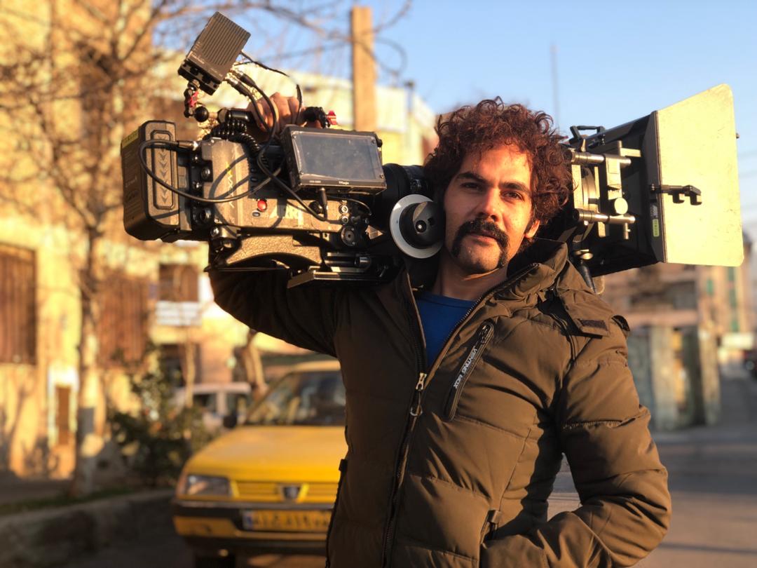 تصویری از احسان باقری، بازیگر و گروه فیلمبرداری سینما و تلویزیون در حال بازیگری سر صحنه یکی از آثارش