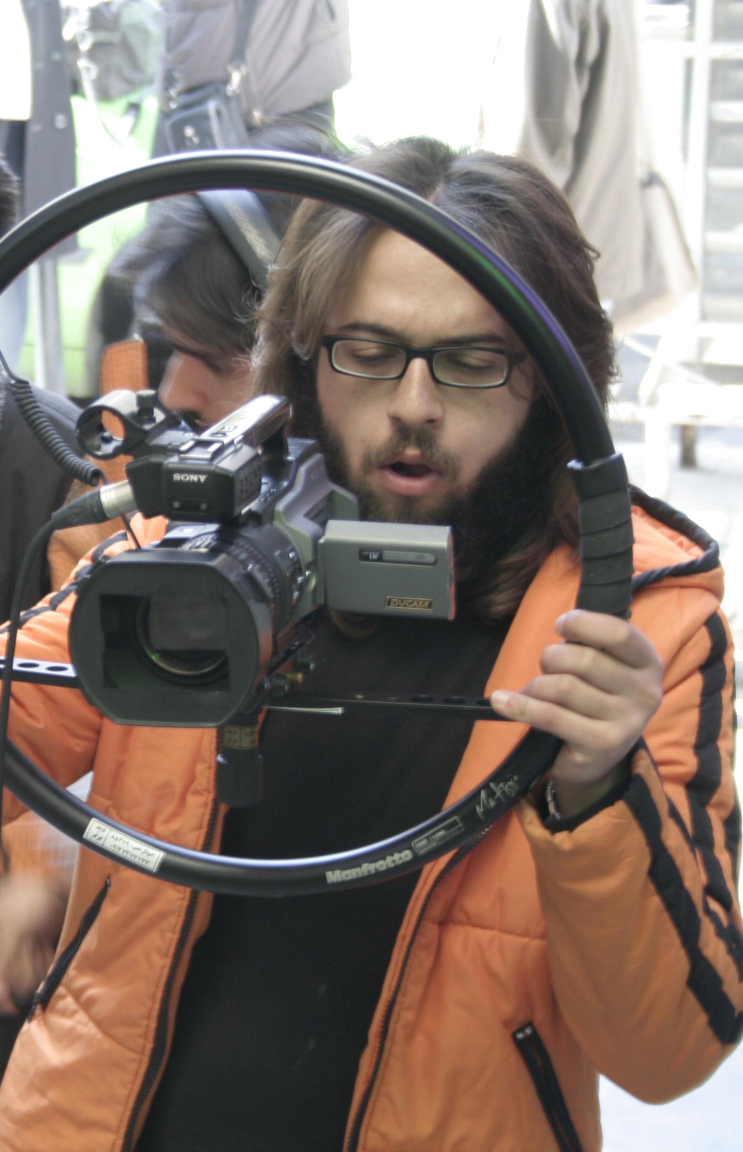 تصویری از بهادر فتاح طاری، عکاس و تدوینگر سینما و تلویزیون در حال بازیگری سر صحنه یکی از آثارش